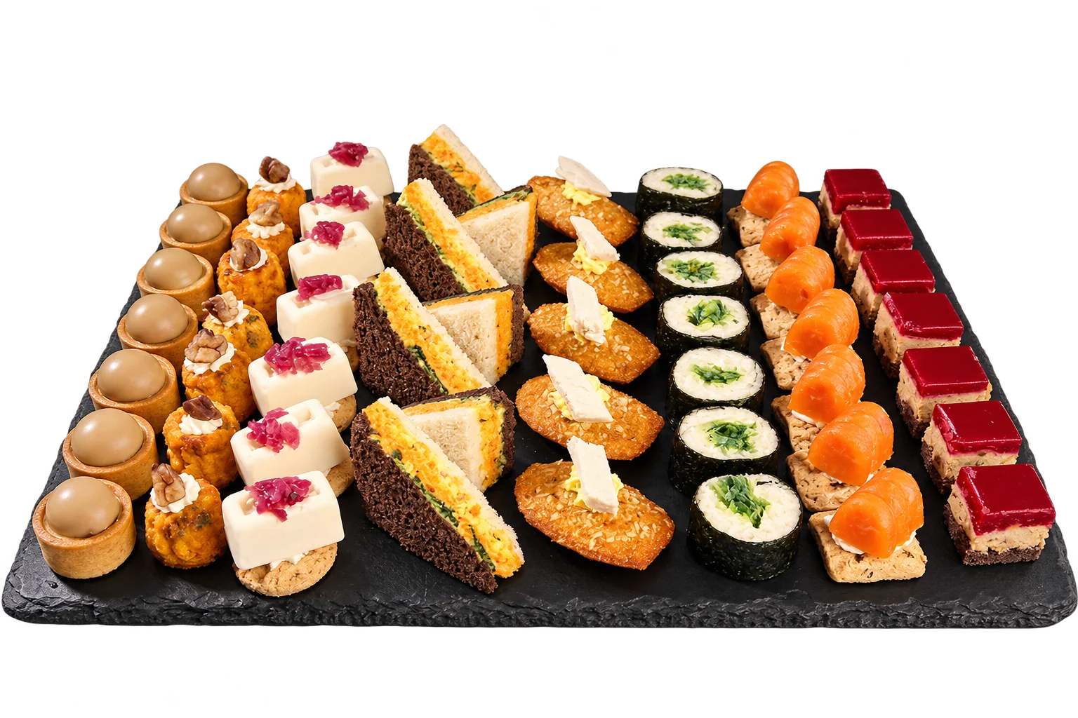 Une ardoise noire présente des rangées de petits fours salés et sucrés : tartelettes, sandwichs, madeleines, makis, saumon et bouchées rouges, sur fond noir.